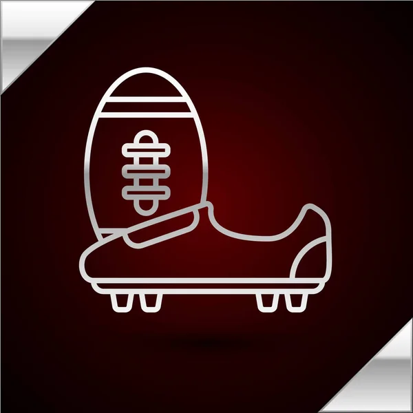 Silberne Linie Fußball oder Fußballschuhe mit Spikes Symbol isoliert auf dunkelrotem Hintergrund. American Football Stiefel und Ball. Vektorillustration — Stockvektor