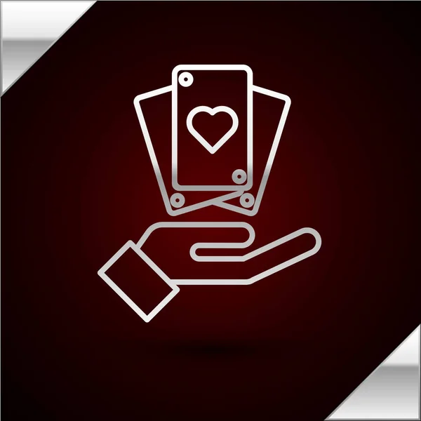 Línea de plata Mano sosteniendo el icono de cartas aisladas sobre fondo rojo oscuro. Diseño del juego de casino. Ilustración vectorial — Vector de stock