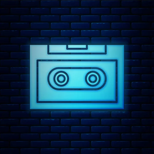 Icono de cinta de casete de audio retro de neón brillante aislado en el fondo de la pared de ladrillo. Ilustración vectorial — Vector de stock