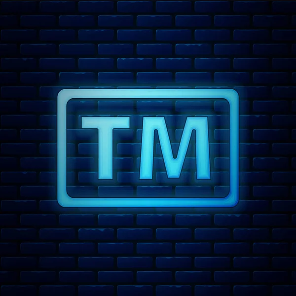 Icono de marca registrada de neón brillante aislado en el fondo de la pared de ladrillo. Abreviatura de TM. Ilustración vectorial — Vector de stock