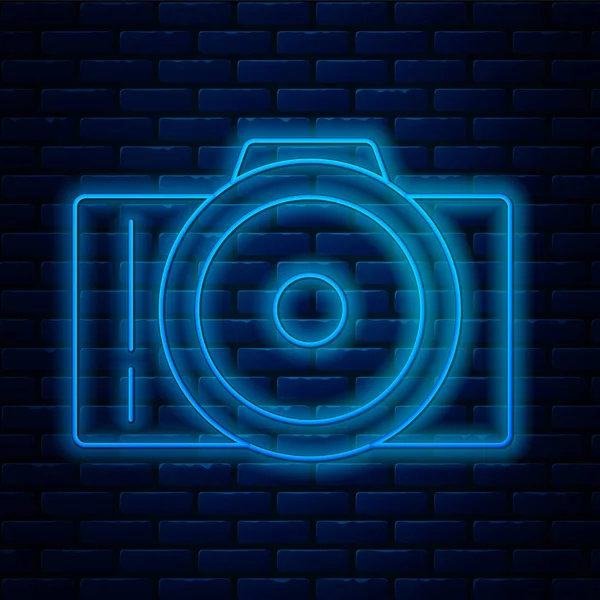 Leuchtende Neon-Linie Fotokamera-Symbol isoliert auf Backsteinwand Hintergrund. Ikone der Fotokamera. Vektorillustration — Stockvektor