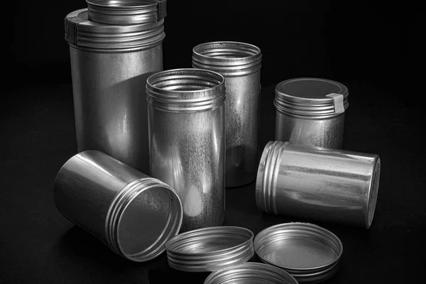 Farklı boyutlarda vida kapaklı yuvarlak metal kavanozlar.