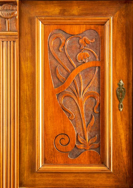 1905 'te Saksonya' da yapılmış ahşap bir dolaptaki güzel Art Nouveau dekoru solda.
