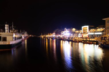 WARNEMUENDE, GERMANY - FEBRUARY 14: The harbor with fisherboats in Warnemuende at night. February 14, 2020 in Warnemuende, Germany