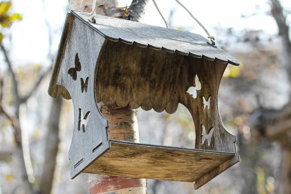 Wooden carved birdfeeder for birds and animals in the city park — Stockfoto