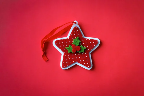 Estrella punteada de fieltro con baya de acebo sobre fondo rojo —  Fotos de Stock
