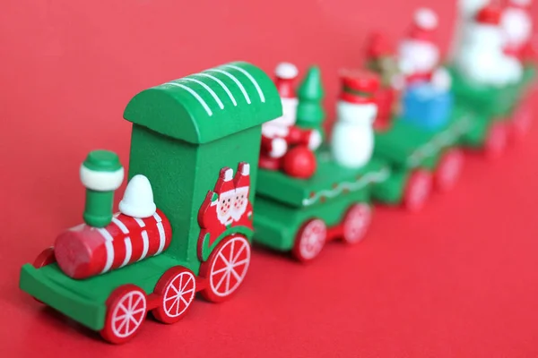Зеленый праздничный деревянный поезд на красном фоне — стоковое фото