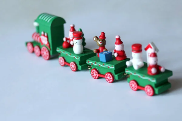 Зеленый праздничный деревянный поезд уезжает на белом фоне с копировальным пространством — стоковое фото