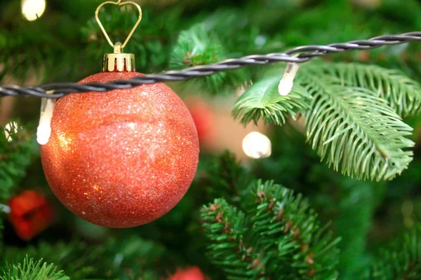 Vánoční stromek zdobený červenými lesklými ozdobami a dřevěnými figurkami — Stock fotografie
