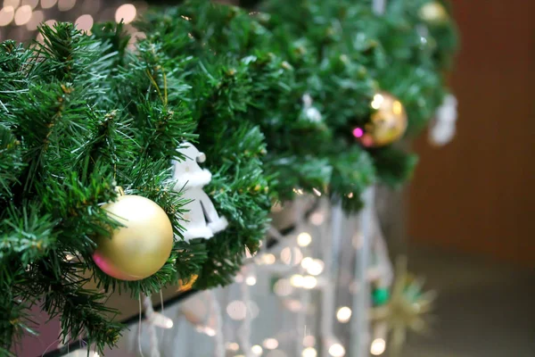 Christmas fir tree branches decorated with golden baubles