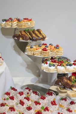 Krem şanti ve taze üzümle süslenmiş mini kekler.