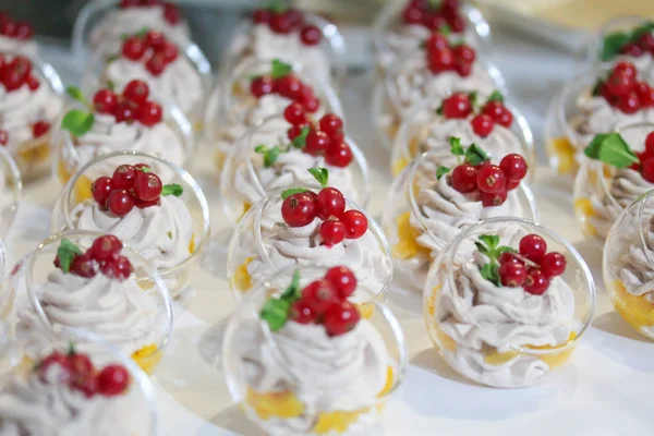 Mini pasteles decorados con crema batida y grosella roja fresca —  Fotos de Stock