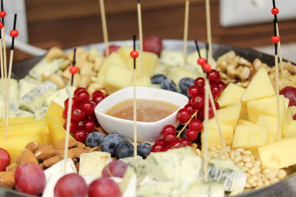 Plato con queso, bayas y nueces en la fiesta —  Fotos de Stock