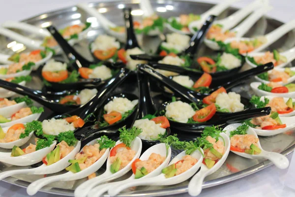 Aperitivos para ensaladas en cucharas de cerámica en el stand-up party o almuerzo buffet —  Fotos de Stock