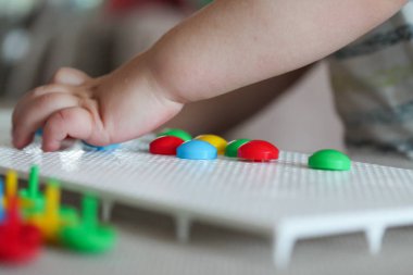 Çocuk tahta mantar çivi mozaiğiyle oynuyor