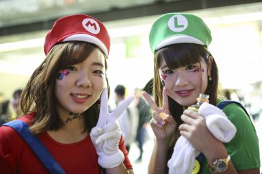 Kostümlü parti katılımcıları 27 Ekim 2018 'de Shibuya' da, Tokyo, Japonya 'da Cadılar Bayramı kutlamaları sırasında toplanırlar. İnsanlar her yıl Cadılar Bayramı 'nı Shibuya' nın ünlü geçidinde ve Roppongi 'nin gece kulübünde kutluyor. Polis varlığı kontrol ediyor.