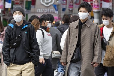 Tokyo, Japonya, 22 Şubat 2020 - Bulaşıcı hastalıkları önlemek için cerrahi maske takan yayalar Shibuya 'nın ünlü geçidinde yürüyor. Japonya, ülkede koronavirüs enfeksiyonu vakalarını doğruladı.