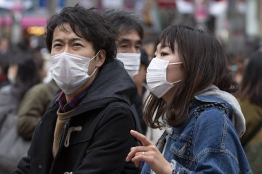 Tokyo, Japonya, 22 Şubat 2020 - Bulaşıcı hastalıkları önlemek için cerrahi maske takan yayalar Shibuya 'nın ünlü geçidinde yürüyor. Japonya, ülkede koronavirüs enfeksiyonu vakalarını doğruladı.