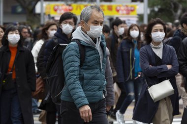 Tokyo, Japonya, 22 Şubat 2020 - Bulaşıcı hastalıkları önlemek için cerrahi maske takan yayalar Shibuya 'nın ünlü geçidinde yürüyor. Japonya, ülkede koronavirüs enfeksiyonu vakalarını doğruladı.