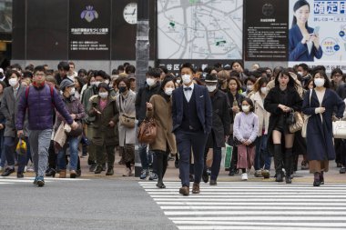 Tokyo, Japonya, 22 Şubat 2020 - Bulaşıcı hastalıkları önlemek için cerrahi maske takan yayalar Shibuya 'nın ünlü geçidinde yürüyor. Japonya, ülkede koronavirüs enfeksiyonu vakalarını doğruladı.