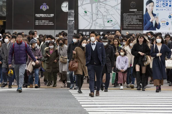 Tokyo, Japonya, 22 Şubat 2020 - Bulaşıcı hastalıkları önlemek için cerrahi maske takan yayalar Shibuya 'nın ünlü geçidinde yürüyor. Japonya, ülkede koronavirüs enfeksiyonu vakalarını doğruladı.