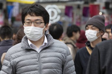 Tokyo, Japonya, 22 Şubat 2020 - Bulaşıcı hastalıkları önlemek için cerrahi maske takan yayalar Shibuya 'nın ünlü geçidinde yürüyor. Japonya, ülkede koronavirüs enfeksiyonu vakalarını doğruladı.