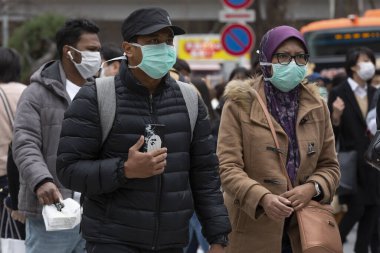 Tokyo, Japonya, 22 Şubat 2020 - Bulaşıcı hastalıkları önlemek için cerrahi maske takan yayalar Shibuya 'nın ünlü geçidinde yürüyor. Japonya, ülkede koronavirüs enfeksiyonu vakalarını doğruladı.