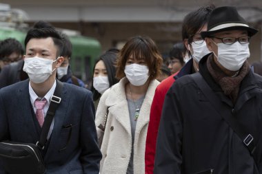 Tokyo, Japonya, 22 Şubat 2020 - Bulaşıcı hastalıkları önlemek için cerrahi maske takan yayalar Shibuya 'nın ünlü geçidinde yürüyor. Japonya, ülkede koronavirüs enfeksiyonu vakalarını doğruladı.
