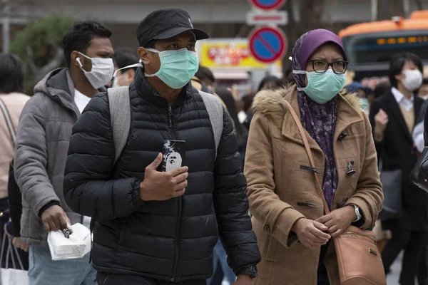 Tokyo, Japonya, 22 Şubat 2020 - Bulaşıcı hastalıkları önlemek için cerrahi maske takan yayalar Shibuya 'nın ünlü geçidinde yürüyor. Japonya, ülkede koronavirüs enfeksiyonu vakalarını doğruladı.