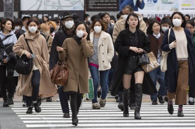 Tokyo, Japonya, 22 Şubat 2020 - Bulaşıcı hastalıkları önlemek için cerrahi maske takan yayalar Shibuya 'nın ünlü geçidinde yürüyor. Japonya, ülkede koronavirüs enfeksiyonu vakalarını doğruladı.