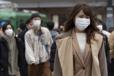 Tokyo, Japonya, 22 Şubat 2020 - Bulaşıcı hastalıkları önlemek için cerrahi maske takan yayalar Shibuya 'nın ünlü geçidinde yürüyor. Japonya, ülkede koronavirüs enfeksiyonu vakalarını doğruladı.