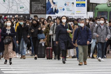 Tokyo, Japonya, 22 Şubat 2020 - Bulaşıcı hastalıkları önlemek için cerrahi maske takan yayalar Shibuya 'nın ünlü geçidinde yürüyor. Japonya, ülkede koronavirüs enfeksiyonu vakalarını doğruladı.