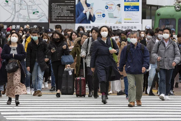 Tokyo, Japonya, 22 Şubat 2020 - Bulaşıcı hastalıkları önlemek için cerrahi maske takan yayalar Shibuya 'nın ünlü geçidinde yürüyor. Japonya, ülkede koronavirüs enfeksiyonu vakalarını doğruladı.