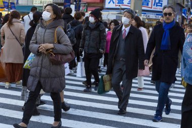 Tokyo, Japonya, 31 Ocak 2020 - Bulaşıcı hastalıkları önlemek için maske takan yayalar Shibuya 'nın ünlü geçidinde yürüyorlar.