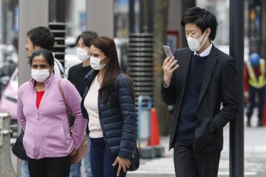 Tokyo, Japonya, 28 Mart 2020 - Ginza alışveriş bölgesinde bulaşıcı hastalıkları önlemek için cerrahi maske takan yayalar görülüyor.