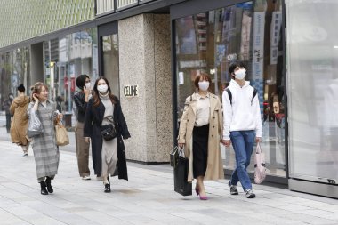 Tokyo, Japonya, 28 Mart 2020 - Bulaşıcı hastalıkları önlemek için cerrahi maske takan yayalar Ginza alışveriş bölgesinde dolaşır.