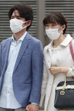 Tokyo, Japonya, 28 Mart 2020 - Bulaşıcı hastalıkları önlemek için cerrahi maske takan yayalar Ginza alışveriş bölgesinde dolaşır.