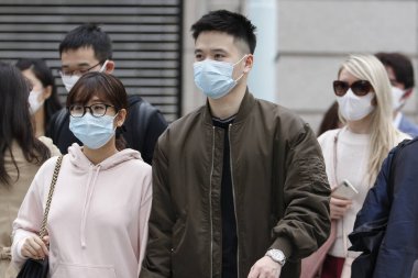 Tokyo, Japonya, 28 Mart 2020 - Bulaşıcı hastalıkları önlemek için cerrahi maske takan yayalar Ginza alışveriş bölgesinde dolaşır.