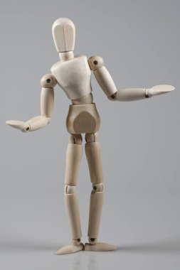 Gri arka planda izole edilmiş ahşap bir manken.