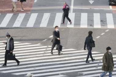 Tokyo, Japonya, 7 Nisan 2020 - Yayalar, Shibuya 'nın ünlü sınır kapısındaki yeni koronavirüs salgını sırasında önleyici bir önlem olarak yüz maskesi takıyorlar.. 