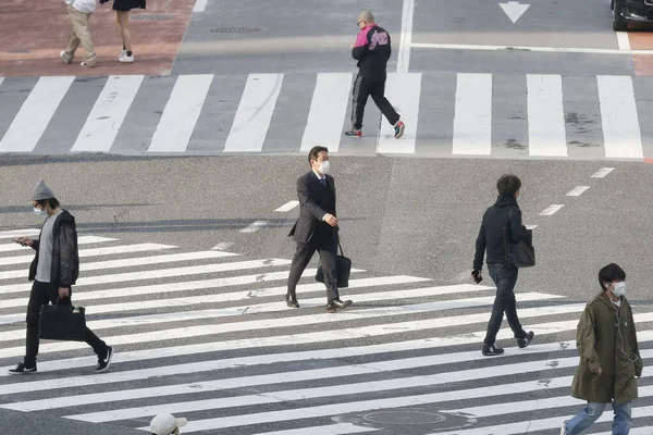 Tokyo, Japonya, 7 Nisan 2020 - Yayalar, Shibuya 'nın ünlü sınır kapısındaki yeni koronavirüs salgını sırasında önleyici bir önlem olarak yüz maskesi takıyorlar.. 