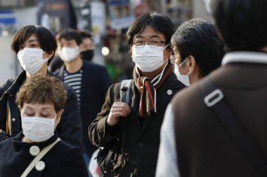 Tokyo, Japonya, 7 Nisan 2020 - Yayalar, Shibuya 'nın ünlü sınır kapısındaki yeni koronavirüs salgını sırasında önleyici bir önlem olarak yüz maskesi takıyorlar.. 