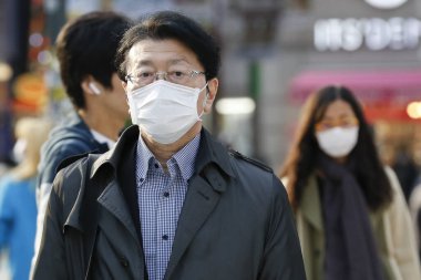 Tokyo, Japonya, 7 Nisan 2020 - Yayalar, Shibuya 'nın ünlü sınır kapısındaki yeni koronavirüs salgını sırasında önleyici bir önlem olarak yüz maskesi takıyorlar.. 