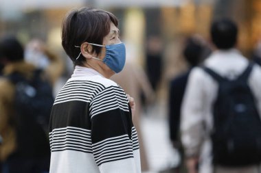 Tokyo, Japonya, 7 Nisan 2020 - Yayalar, Shibuya 'nın ünlü sınır kapısındaki yeni koronavirüs salgını sırasında önleyici bir önlem olarak yüz maskesi takıyorlar.. 