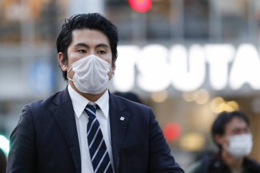 Tokyo, Japonya, 7 Nisan 2020 - Yayalar, Shibuya 'nın ünlü sınır kapısındaki yeni koronavirüs salgını sırasında önleyici bir önlem olarak yüz maskesi takıyorlar.. 