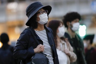 Tokyo, Japonya, 7 Nisan 2020 - Yayalar, Shibuya 'nın ünlü sınır kapısındaki yeni koronavirüs salgını sırasında önleyici bir önlem olarak yüz maskesi takıyorlar.. 