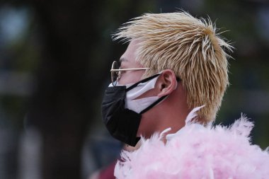 Tokyo, Japonya, 7 Nisan 2020 Shibuya 'nın ünlü sınır kapısında meydana gelen yeni Coronavirus salgını sırasında bir adam çift maske takıyor.. 