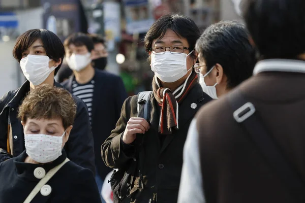 Tokyo, Japonya, 7 Nisan 2020 - Yayalar, Shibuya 'nın ünlü sınır kapısındaki yeni koronavirüs salgını sırasında önleyici bir önlem olarak yüz maskesi takıyorlar.. 
