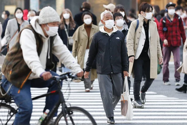 Tokyo, Japonya, 7 Nisan 2020 - Yayalar, Shibuya 'nın ünlü sınır kapısındaki yeni koronavirüs salgını sırasında önleyici bir önlem olarak yüz maskesi takıyorlar.. 