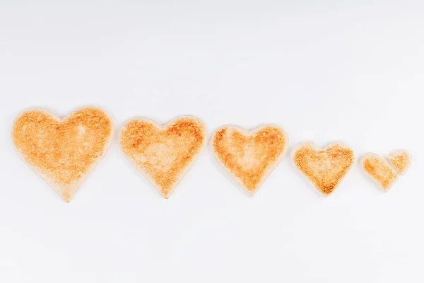 Group of toasted bread hearts with one broken heart together on white background — Stock Photo, Image